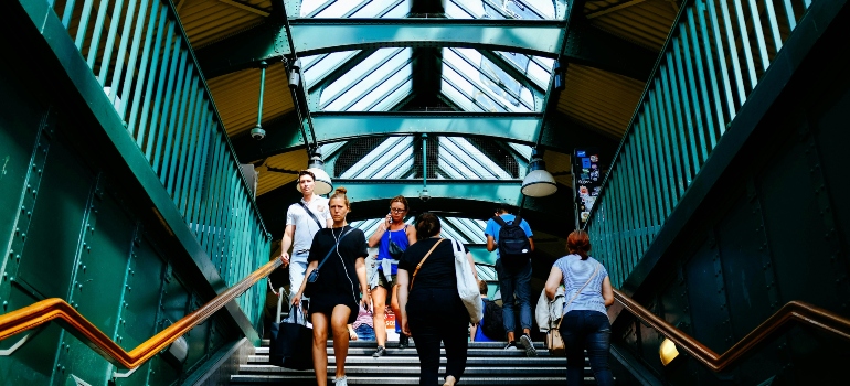 People walking on stairs near a public transportation hub, representing the daily commute after moving from Calgary to Burlington.