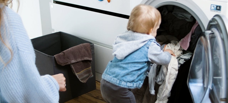 Child putting clothes in a washer