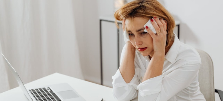 Person crying at a table stressed about relocating your home office