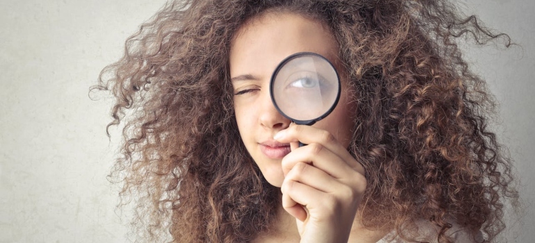 Person looking through a magnifying glass