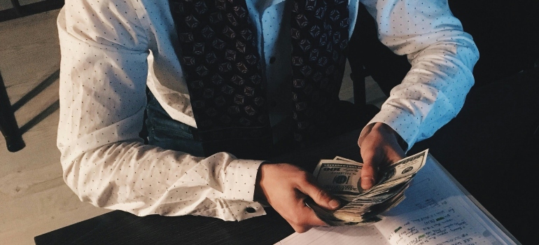 A man counting money, symbolizing hidden fees from unreliable moving companies