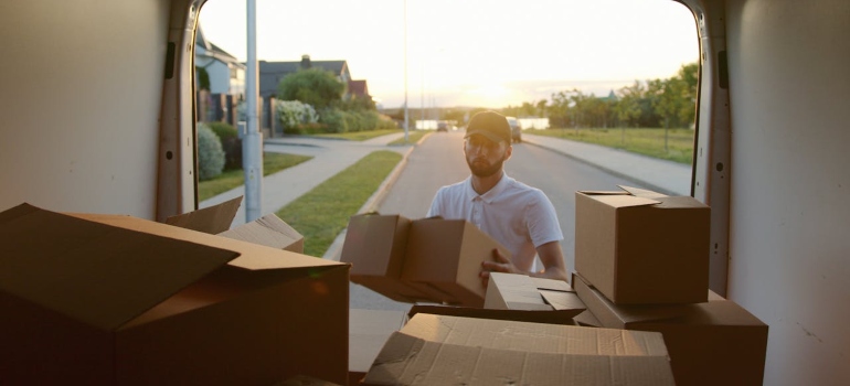 Person loading boxes into a van in order to accomplish a stress-free relocation
