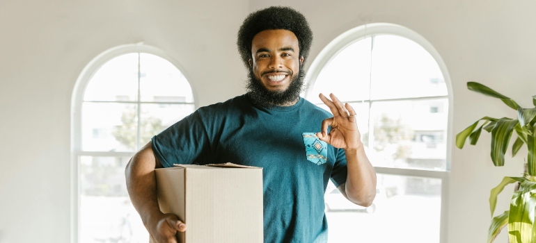 A reliable mover holding a box, showcasing professionalism and care during the moving process avoiding red flags of unprofessional movers