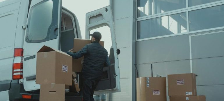 a boy packing boxes into the van