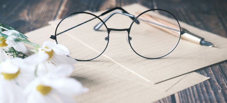 Glasses, pen and flowers on papers