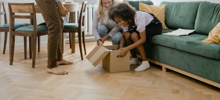 The exiting girl is opening the box in front of her parents.