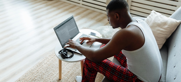 A man is searching for ways to safeguard hardwood floors during relocations on his laptop.