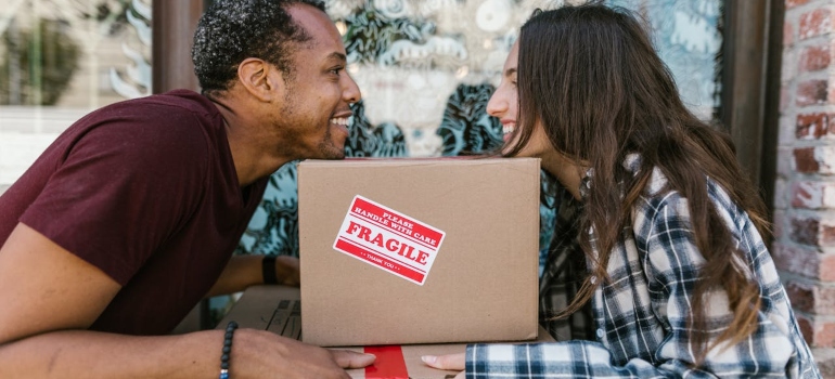 People leaning on a labeled box
