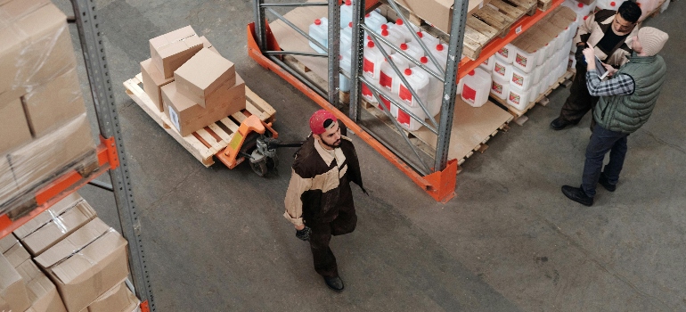 Man organizing boxes in a large climate-controlled storage unit.