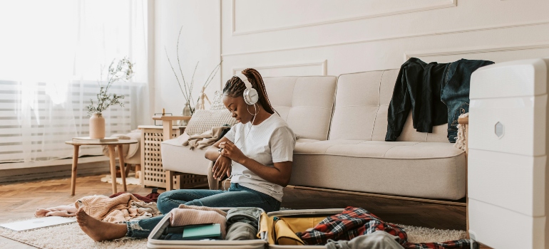 a girl sitting on the floor and listening to music