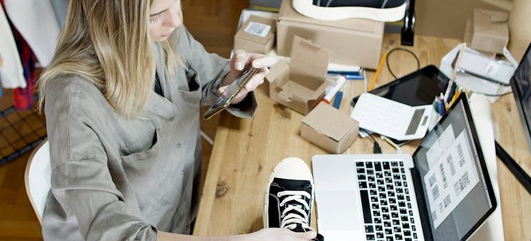 Woman taking photos of items for sale as she prepares to organize a yard sale before moving and promote it online.