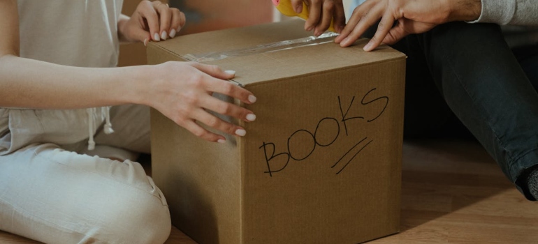 Couple opening a box after relocating with a big family