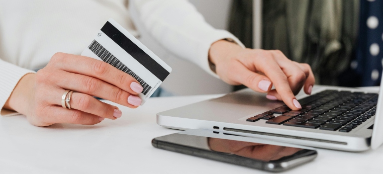 Person Using a Laptop and Holding a Credit card