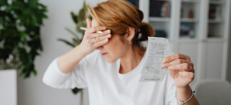 Unhappy Woman Holding Bill