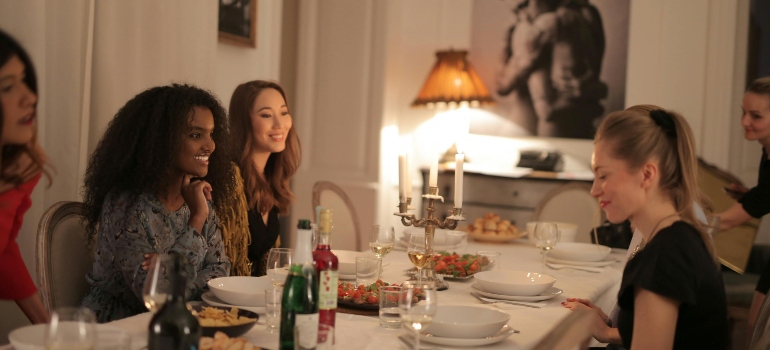Farewell suggestions for friends relocating shown through women sharing a dinner together, celebrating friendship and saying goodbye before a move.