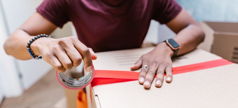 Person securing a box with tape