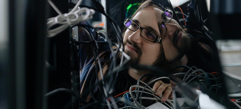 Technician organizing network cables to protect systems during temporary office storage during a Toronto move.