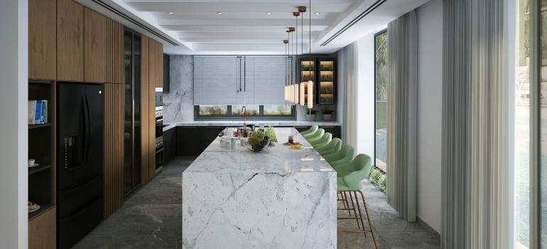 Modern kitchen with marble island and cabinets representing heavy household items during a move.