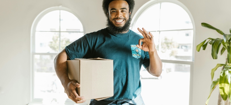 Moving professional carrying a sealed box for temporary office storage during a Toronto move.