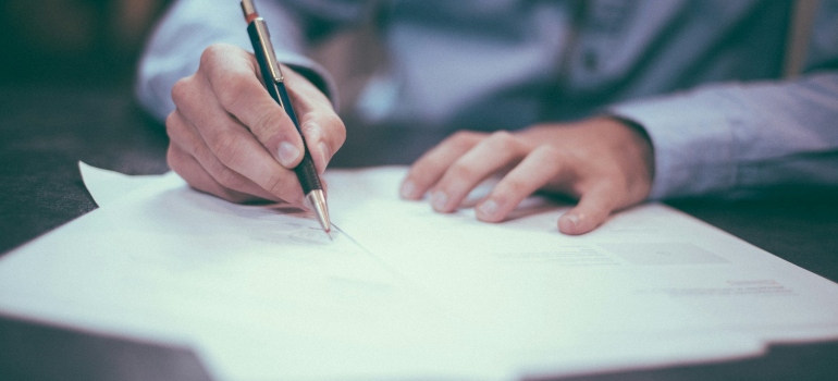 Person signing a contract after leaving Newmarket for a warmer city