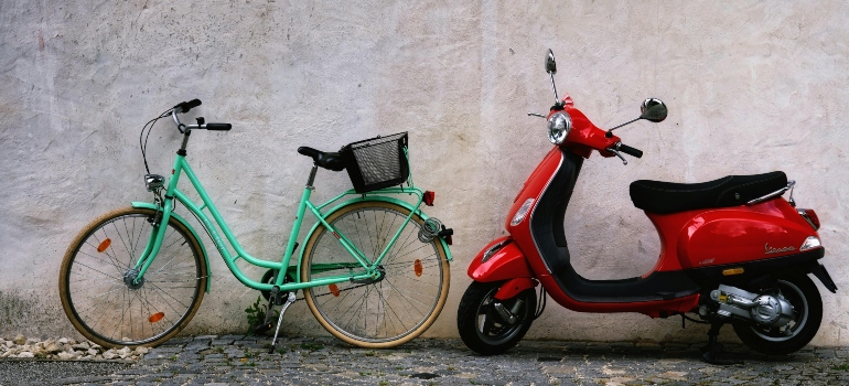 Bicycle and scooter parked near a wall