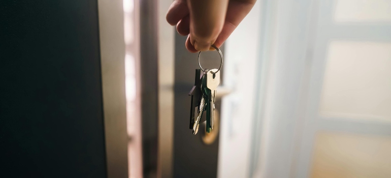 Hand holding new apartment keys during relocating to your first home process.