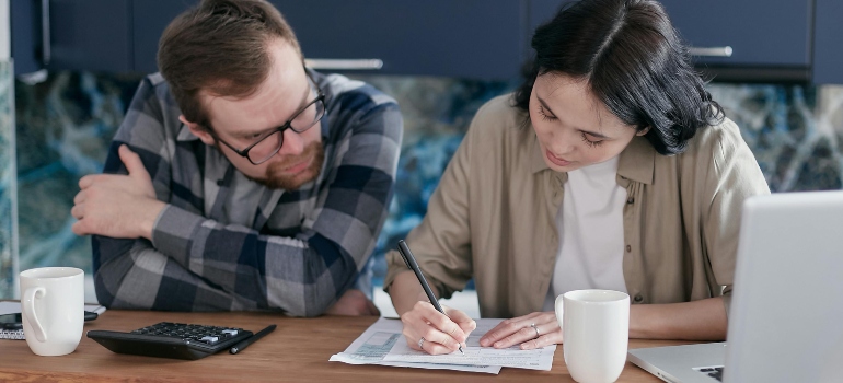 Couple discussing relocation costs and budgeting at a table before their move.