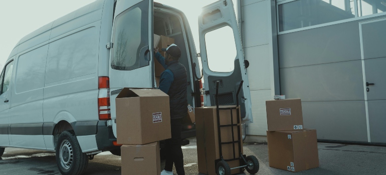 Crew loading commercial equipment and boxes into a van for a cost-effective business move with storage.