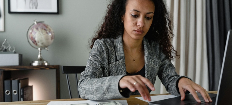 Office employee reviewing paperwork and preparing files for business relocation.